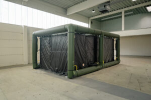 Aufgebautes Zeltsystem mit aufblasbarer Rahmenkonstruktion und geschlossener Zeltwand in einer Halle.